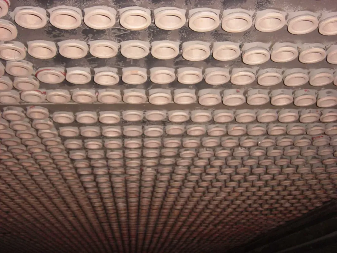 Rows of ceramic air heater inserts in a tubesheet seen from below