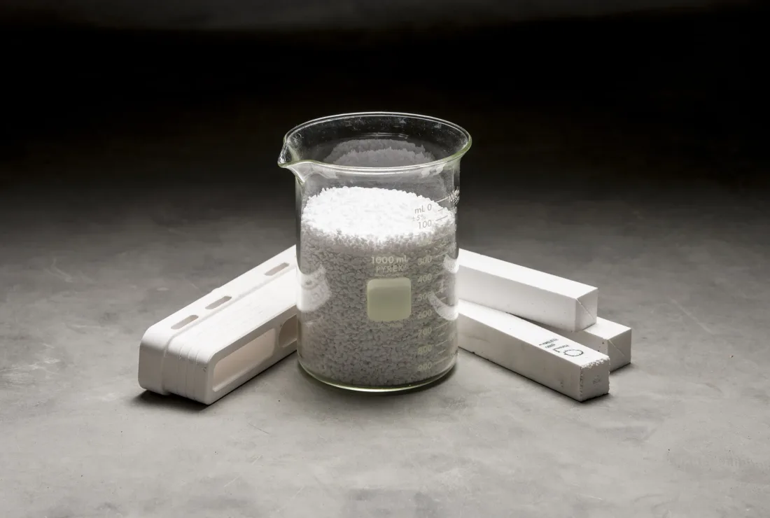 Calcium silicate shapes next to a beaker of raw material