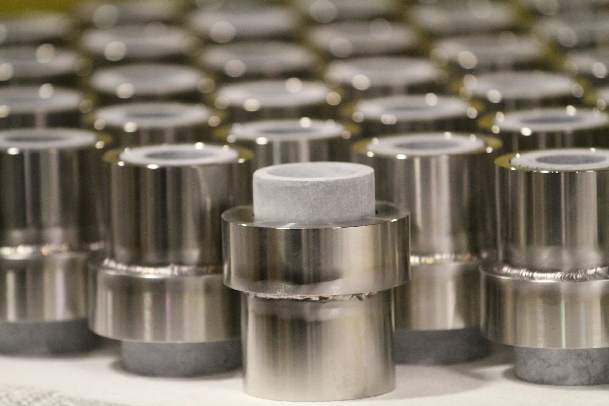 Ceramic nozzle inserts welded into polished steel sleeves
