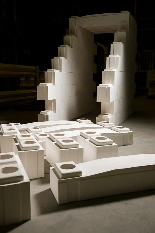 Interlocking white ceramic blocks with a doorway shaped wall behind them