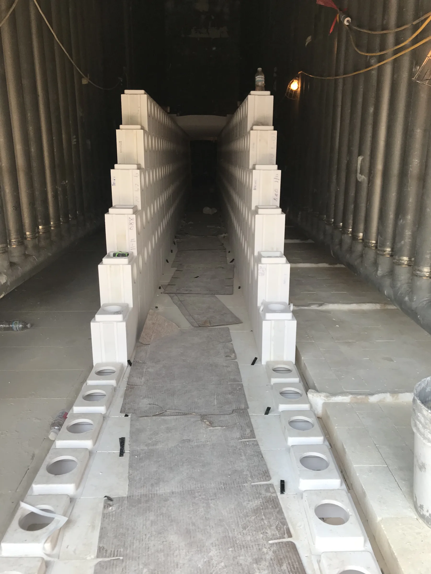 Two precast tunnel walls on the floor of a reformer furnace during installation