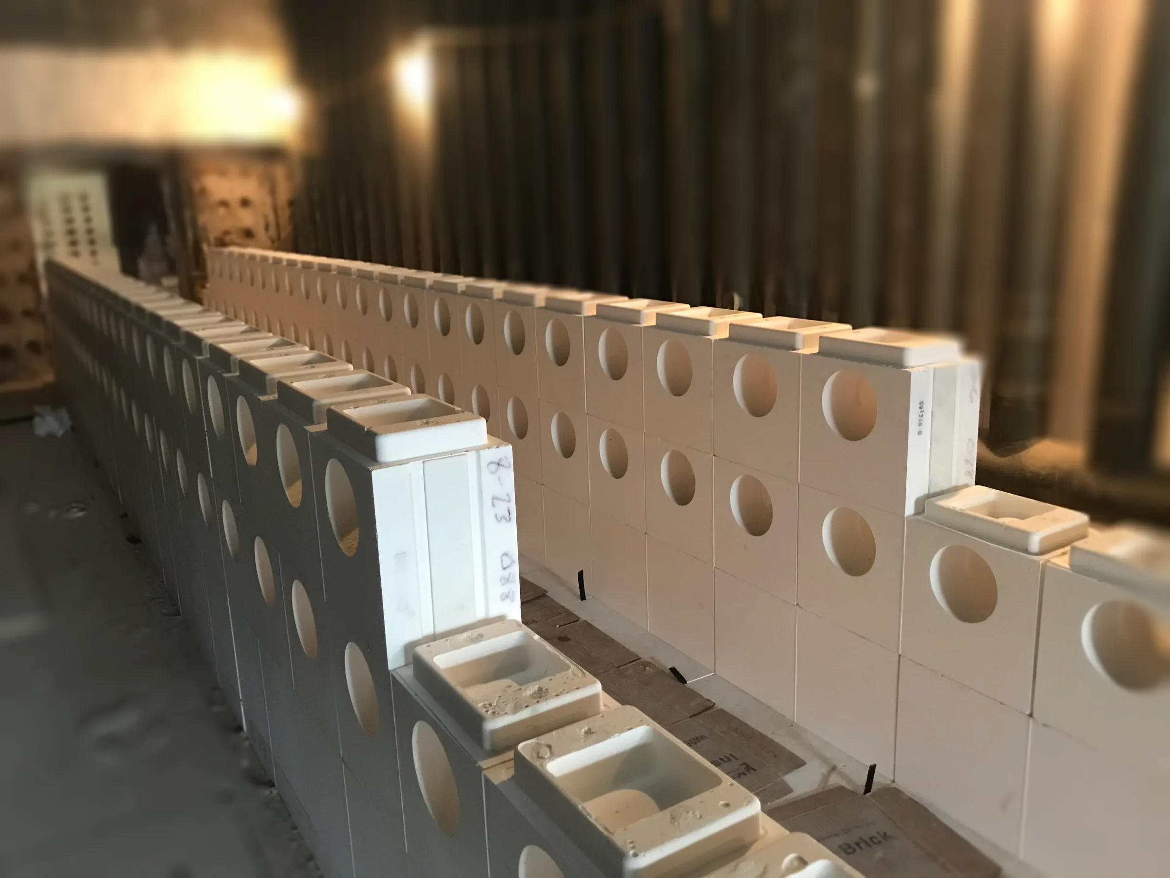 Precast tunnel wall being built block by block in a furnace