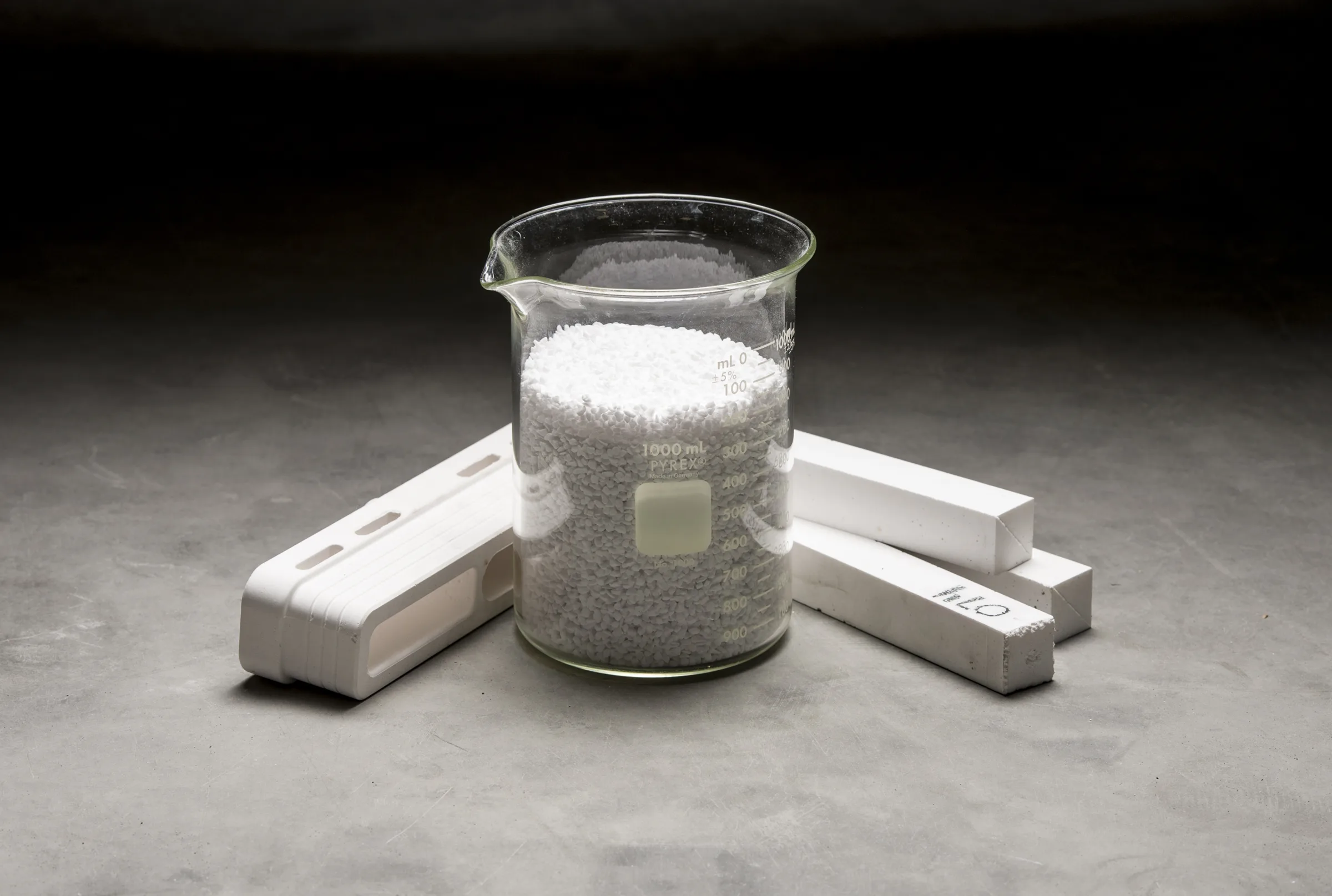 Calcium silicate shapes next to a beaker of raw material